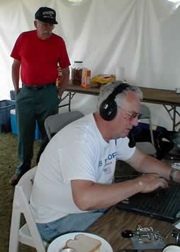 Henry/KT1J working the station while Dick/AI1C looks on.